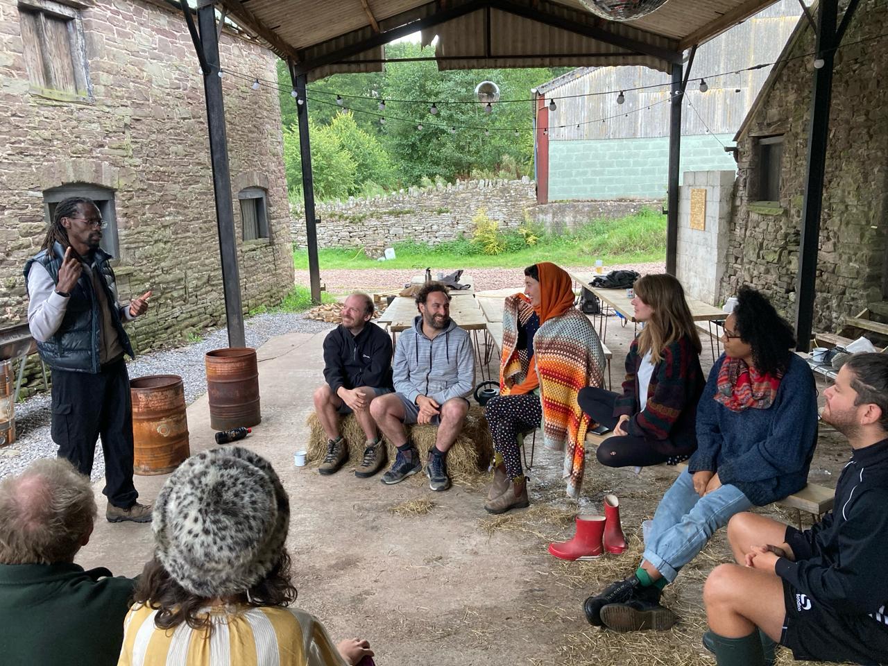 Kwame Afrik teaching British Sign Language to a group outdoors